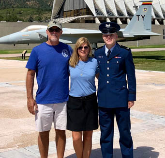 Three adults standing in front of an airplane