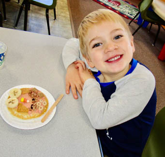 Smiling child with a plate of food